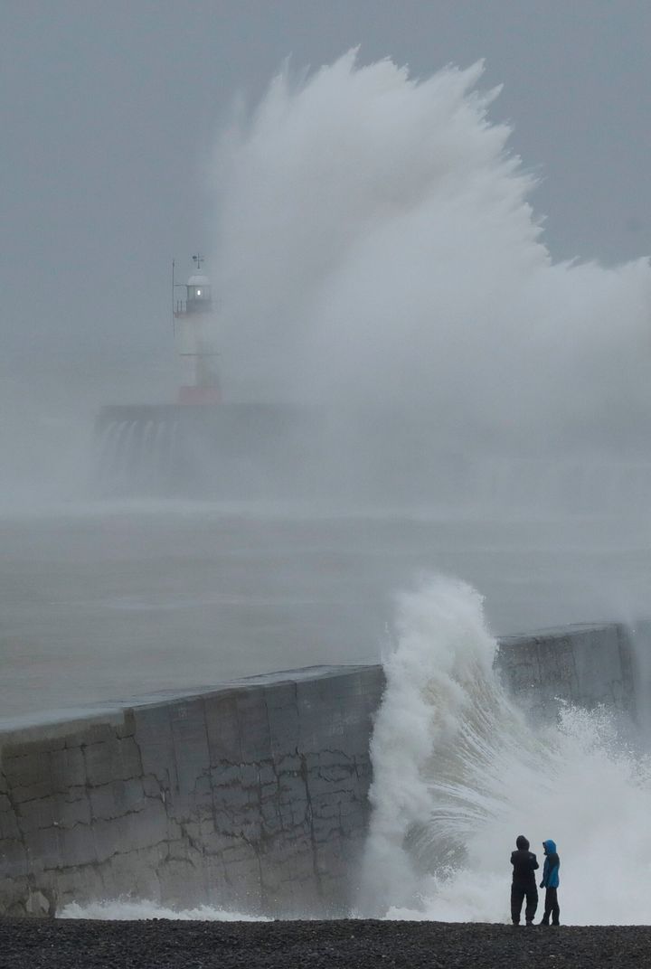 Waves crash over the harbour wall by a lighthouse as Storm Ciara hits Newhaven, on the south coast of England on Sunday 