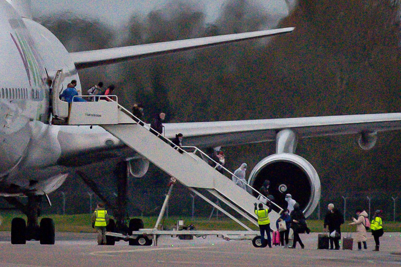 People wearing facemasks disembark from an aircraft repatriating Brits to the UK from Wuhan in China at RAF Brize Norton 
