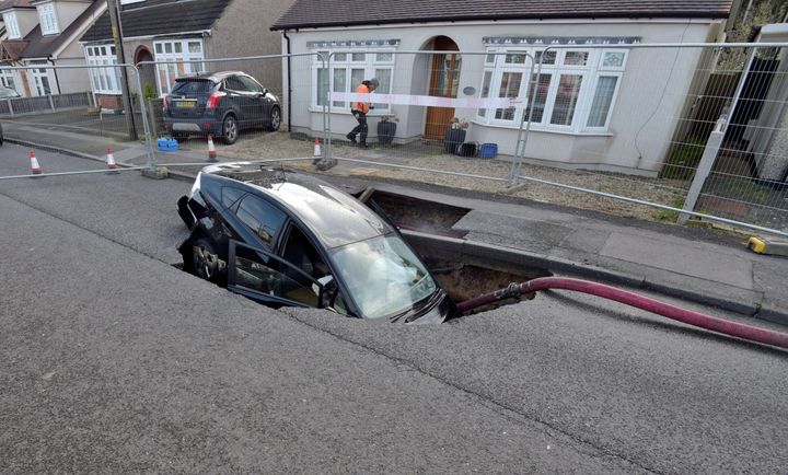 A view of a Toyota car in a sinkhole which appeared overnight in the aftermath of Storm Ciara, in Brentwood