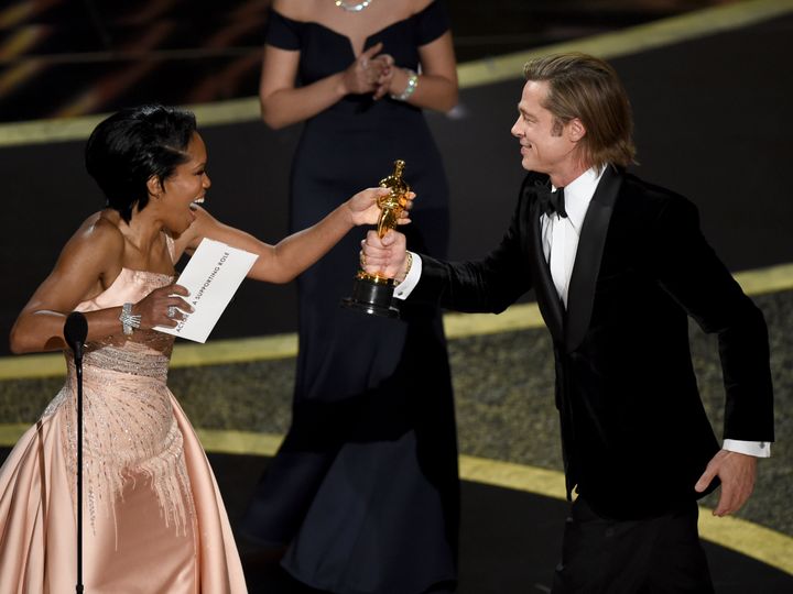 Regina King, left, presents Brad Pitt with the award for best performance by an actor in a supporting role for "Once Upon a Time in Hollywood" at the Oscars on Sunday, Feb. 9, 2020, at the Dolby Theatre in Los Angeles. (AP Photo/Chris Pizzello)