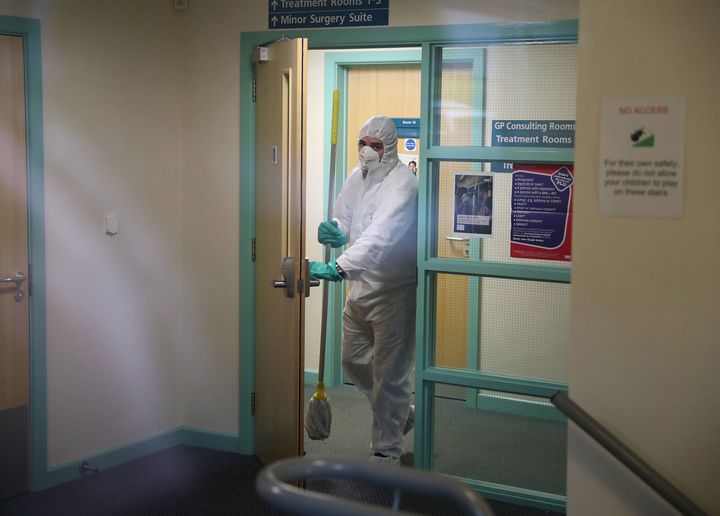A man in protective clothing cleaning the County Oak Medical Centre GP practice in Brighton which has been temporarily closed "because of an urgent operational health and safety reason".
