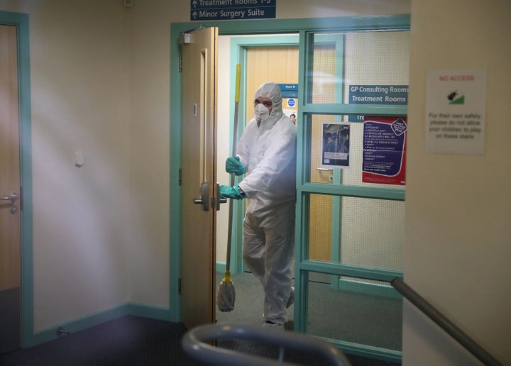 <strong>A man in protective clothing cleaning the County Oak Medical Centre GP practice in Brighton which has been temporarily closed "because of an urgent operational health and safety reason".</strong>