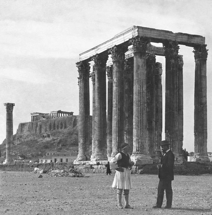 Ένας τσολιάς και ένας αστός συζητούν μπροστά στους στύλους του Ολυμπίου Διός (τέλη του 19ου, αρχές του 20ου αιώνα)