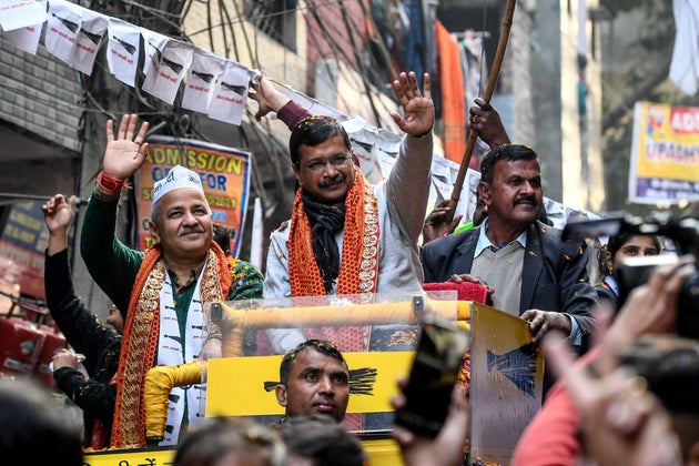 Aam Aadmi Party leader Arvind Kejriwal waves to his supporters during a rally for the upcoming Delhi...