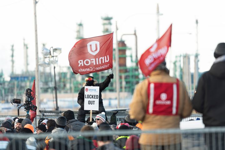 A man holds a Unifor flag during a rally at the Co-op Refinery in Regina on Tuesday Jan. 21, 2020. 