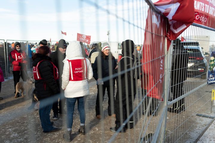 Unifor members stand near a fence at Gate 7 at the Co-op Refinery in Regina on Tuesday Jan. 21, 2020. 