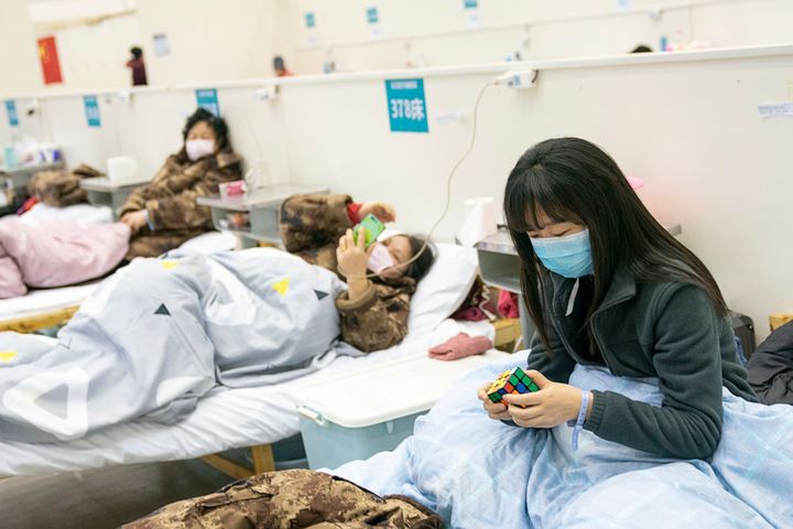 A patient solves a Rubik's cube at a temporary hospital converted from "Wuhan Livingroom" in Wuhan, central China's Hubei Province, Feb. 10, 2020.