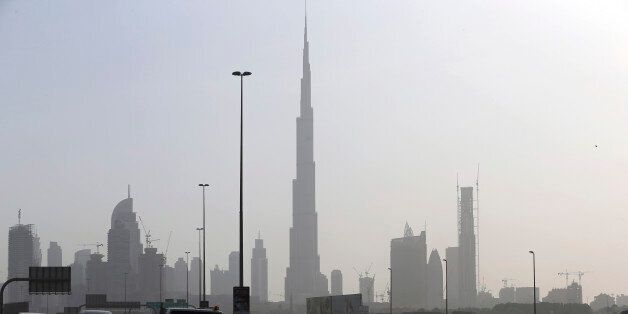 Cars pass by the city skyline with the Burj Khalifa, world tallest tower in background, Tuesday, July 28, 2015, in Dubai, United Arab Emirates. The United Arab Emirates has slashed gasoline subsidies, announcing Tuesday that it will raise the cost of a liter of regular gasoline by 24 percent amid globally low oil prices that have cut into the country's revenues. (AP Photo/Kamran Jebreili)
