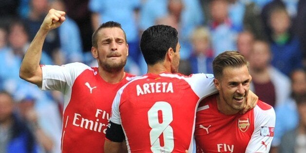 Arsenal's Welsh midfielder Aaron Ramsey (C) celebrates scoring their second goal with Arsenal's French defender Mathieu Debuchy (L) and Arsenal's Spanish midfielder Mikel Arteta (C) during the FA Community Shield football match between Arsenal Manchester City at Wembley Stadium in north London on August 10, 2014. AFP PHOTO / GLYN KIRK-- NOT FOR MARKETING OR ADVERTISING USE / RESTRICTED TO EDITORIAL USE (Photo credit should read GLYN KIRK/AFP/Getty Images)