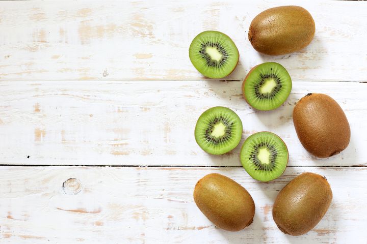 Kiwi fruit on white wooden background