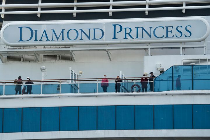 Passengers on board the Diamond Princess cruise ship are seen as the ship arrives at Daikoku Pier where it is being resupplied and newly diagnosed coronavirus cases taken for treatment as it remains in quarantine, on February 12, 2020 in Yokohama, Japan.