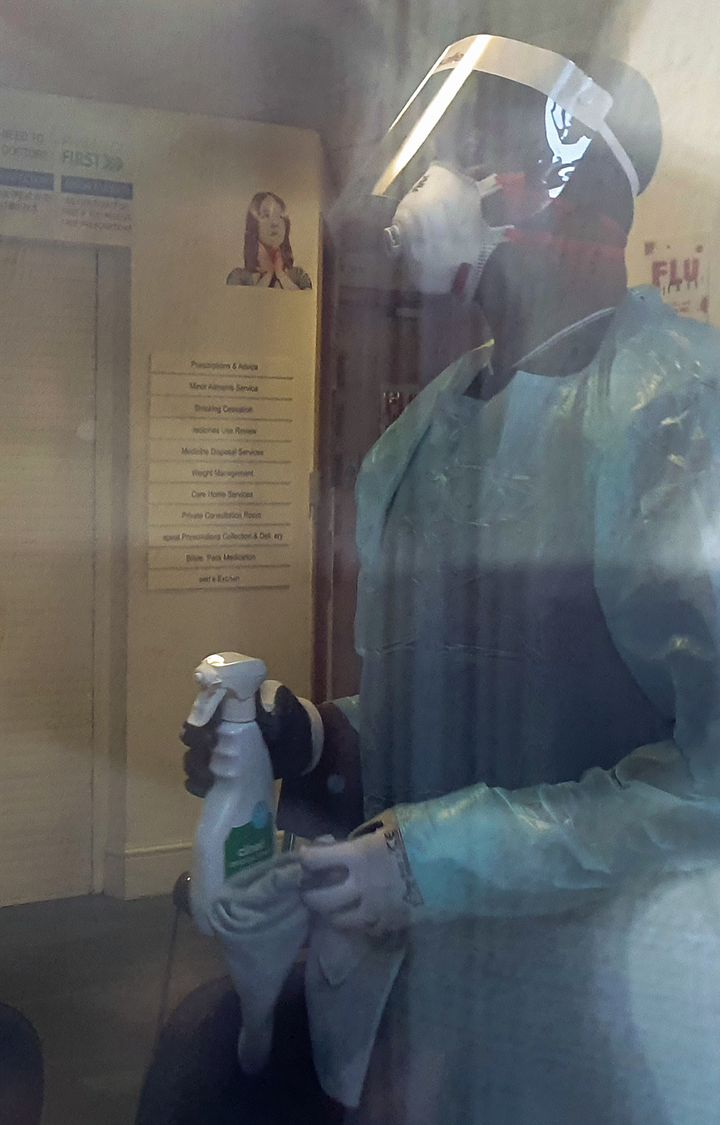 A man in a hazmat suit and face mask cleans the Ritchie Street Health Centre, Islington, North London, which was closed 'due to operational difficulties'