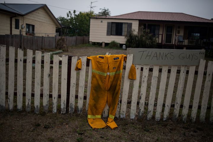 A firefighter's suit hangs on a fence next to a "Thanks guys" sign in Cobargo, New South Wales, Australia, on Jan. 12.