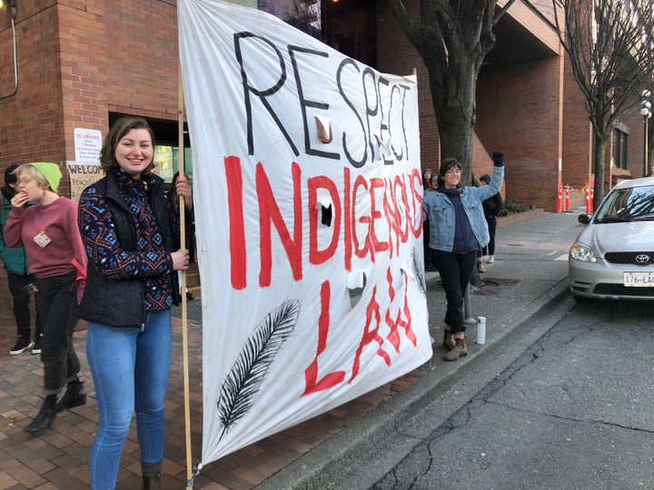 Allies of the Wet'suwet'en hereditary chiefs stand with a sign reading "Respect Indigenous Law" outside a B.C. provincial ministry building in Victoria on Feb. 14, 2020.