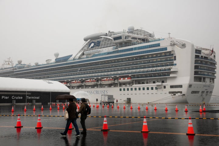 Visitors walk past the quarantined Diamond Princess cruise ship in Yokohama, near Tokyo. Americans who have not testes positi