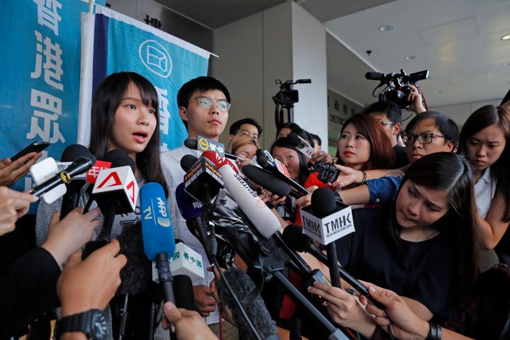 Pro-democracy activists Joshua Wong, right, and Agnes Chow speak to media outside a district court in Hong Kong, Friday, Aug. 30, 2019. Hong Kong activist Joshua Wong and another core member of a pro-democracy group were granted bail Friday after being charged with inciting people to join a protest in June, while authorities denied permission for a major march in what appears to be a harder line on this summer's protests. (AP Photo/Kin Cheung)