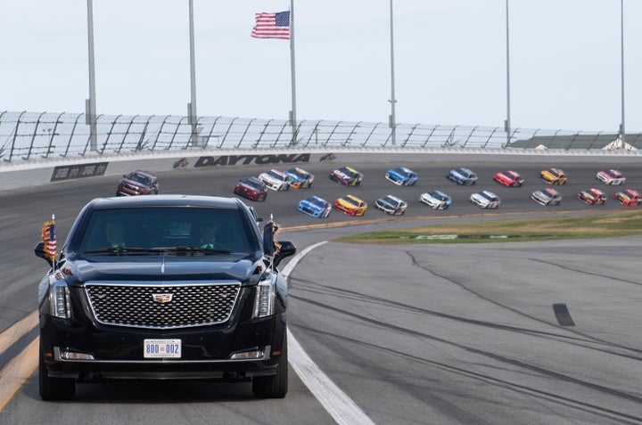 President Donald Trump and first lady Melania Trump ride in the presidential limousine as they take a pace lap ahead of the s