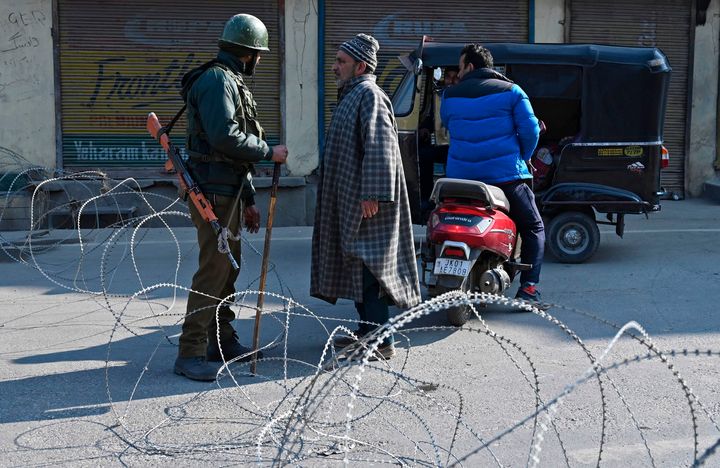 Paramilitary trooper talks to a man at a checkpoint during a one-day strike called by Jammu and Kashmir Libration Front in Srinagar on February 9, 2020. 