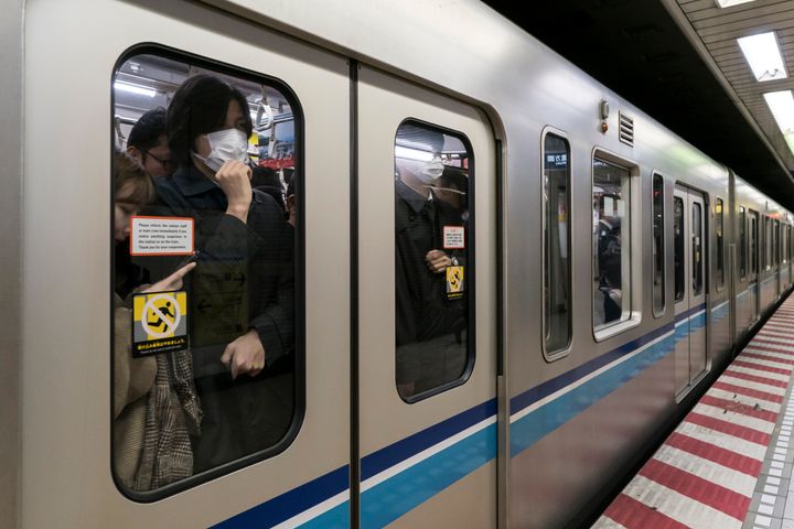 マスクをして満員電車に乗る人々のイメージ
