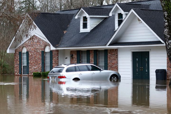 Water from the Pearl River floods this Jackson, Mississippi home and car on Sunday.