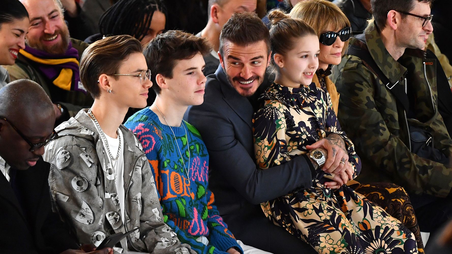 David Beckham's daughter Harper sits on his lap as wife Victoria