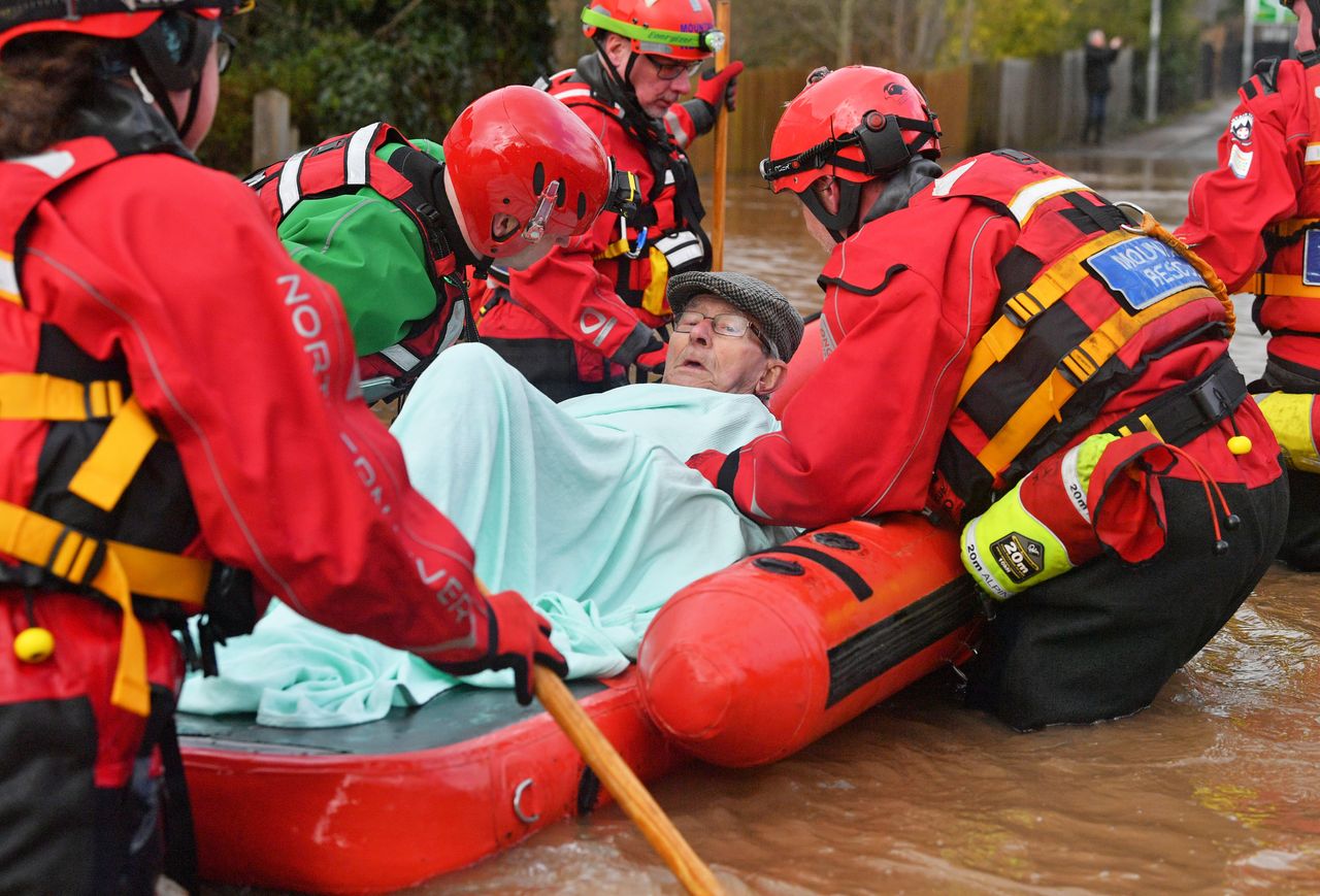 Mountain Rescue team members rescue Peter Morgan from his house where he has lived his whole life, which has been flooded in Monmouth