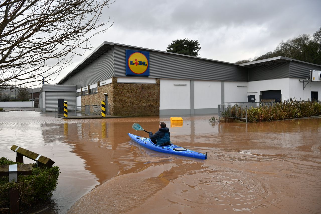 A canoeist makes their way towards Lidl in Monmouth in the aftermath of Storm Dennis