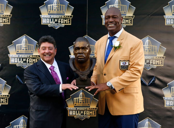 Former NFL player Charles Haley, right, poses with his bust, next to his present, former San Francisco 49ers owner Edward DeBartolo Jr., during inductions at the Pro Football Hall of Fame, Saturday, Aug. 8 2015, in Canton, Ohio.