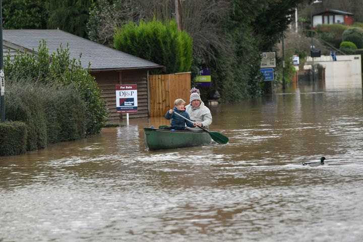 Nearby residents making their way through floodwater by boat in Monmouth.