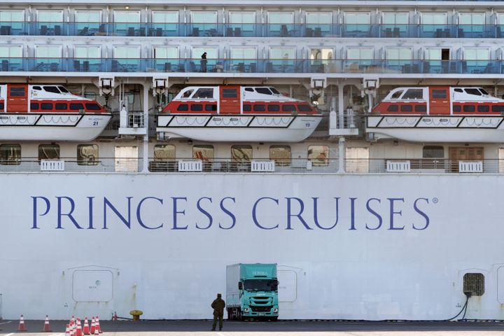 A passenger stands on the balcony of the quarantined cruise ship Diamond Princess on Sunday, Feb. 9.