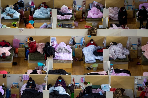Patients infected with the coronavirus take rest at a temporary hospital converted from the Wuhan Sports...