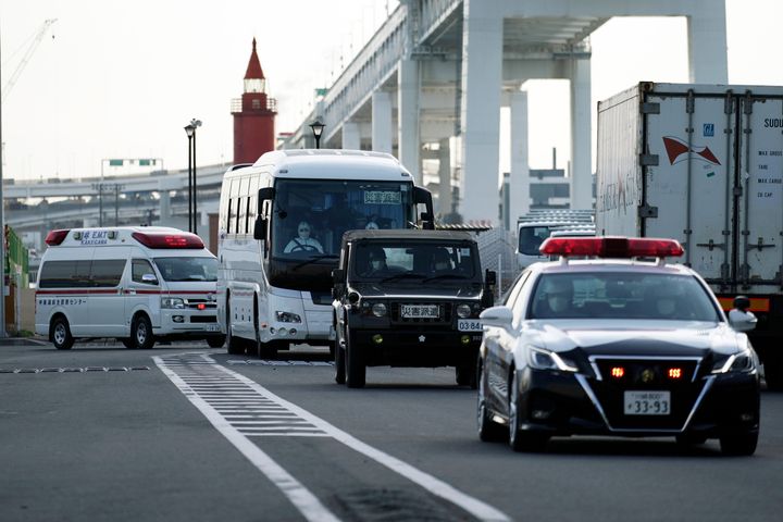 A bus carrying the passengers from the quarantined Diamond Princess cruise ship leaves a port in Yokohama