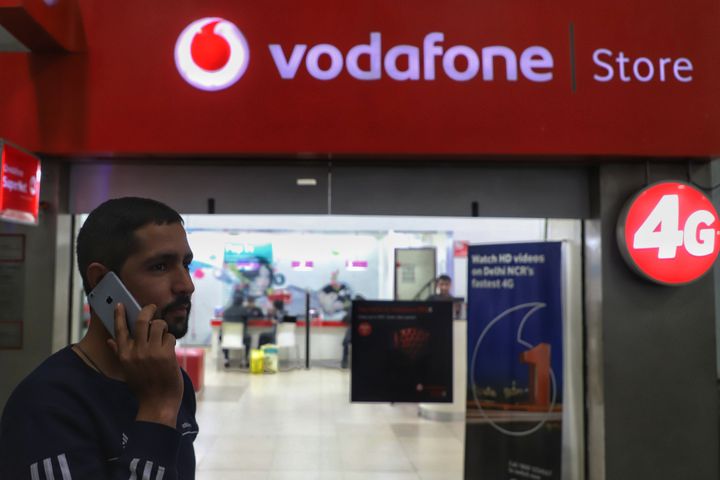 A man talks on a cell phone near a Vodafone showroom in New Delhi on 4 January 2020.