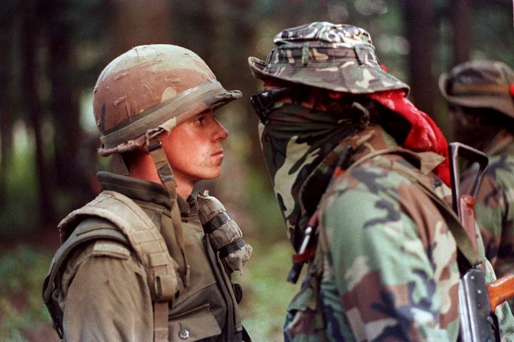 Cette photo devenue emblématique de la Crise d'Oka montre le soldat Patrick Cloutier et le Warrior ojibwé Brad Laroque, alias "Freddy Kruger", dans un face à face tendu sur la pinède de Kanesatake, le 1er septembre 1990. (Shaney Komulainen/La Presse canadienne)