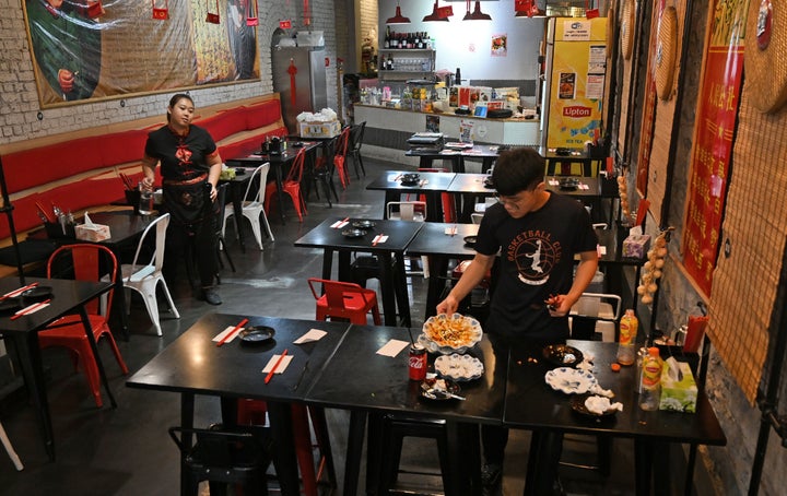 This photo taken on February 14, 2020 shows staff clearing a table at a Chinese restaurant in Melbourne's Chinatown. 