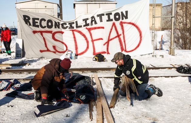 A supporter of the Wet'suwet'en hereditary chiefs, left, and a counter protestor remove a blockade after...