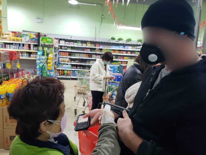 One of the authors getting his temperature checked as he enters the grocery store.