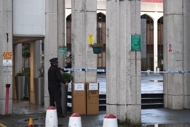 A police officer distributes crime scene tape after an attack at the London Central Mosque in Park Road, near Regent's Park.