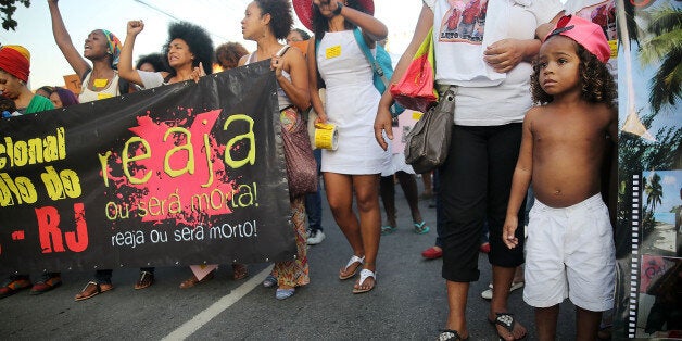 RIO DE JANEIRO, BRAZIL - AUGUST 22: Demonstrators march through the Manguinhos favela to protest against police killings of blacks on August 22, 2014 in Rio de Janeiro, Brazil. Every year, Brazil's police are responsible for around 2,000 deaths, one of the highest rates in the world. Many of the deaths in Rio involve blacks killed in favelas, also known as slums. (Photo by Mario Tama/Getty Images)