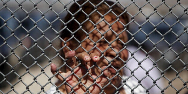 A Mexican migrant talks to a family member through the border fence between Ciudad Juarez and El Paso, United States, after a bi-national Mass in support of migrants in Ciudad Juarez, Mexico, February 15, 2016. According to the organizers of the event, the Mass was organized to bring together dozens of families of Mexican migrants living in the U.S. and who, based on their immigration status, will not be able to join their families in Mexico when Pope Francis celebrates Mass in Ciudad Juarez on February 17. REUTERS/Jose Luis Gonzalez