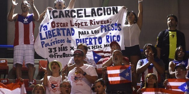 Some Puerto Rico's fans hold a banner demanding the release of Puerto Rican political prisoner Oscar Lopez Rivera during the 2014 FIBA World basketball championships group B match Senegal vs Puerto Rico at the Palacio Municipal de Deportes in Sevilla on August 31, 2014. AFP PHOTO/ PIERRE-PHILIPPE MARCOU (Photo credit should read PIERRE-PHILIPPE MARCOU/AFP/Getty Images)