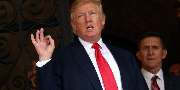 U.S. President-elect Donald Trump talks to members of the media as retired U.S. Army Lieutenant General Michael Flynn stands next to him at Mar-a-Lago estate in Palm Beach, Florida, U.S., December 21, 2016. REUTERS/Carlos Barria