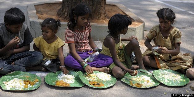Indian homeless eat food at a feeding programme for the poor in Hyderabad on March 17, 2013. India still has the worlds largest number of impoverished in a single country, of its nearly one billion inhabitants, an estimated 350-400 million live below the poverty line with 75 percent of them in the rural areas. AFP PHOTO / Noah SEELAM (Photo credit should read NOAH SEELAM/AFP/Getty Images)