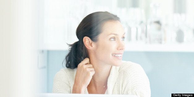 Happy middle aged woman thinking something while looking away