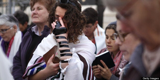 A member of the liberal religious group Women of the Wall wearing phylacteries and a 'Tallit' traditional Jewish prayer shawl for men prays at the Western Wall in Jerusalem's Old City on April 11, 2013 marking the first day of the Jewish month of Iyar. Five members of the Women of the Wall organisation were detained by police in the midst of the liberal group's monthly prayer at the Western Wall, after covering themselves with a prayer shawl in contradiction to the holy site's custom. AFP PHOTO/GALI TIBBON (Photo credit should read GALI TIBBON/AFP/Getty Images)