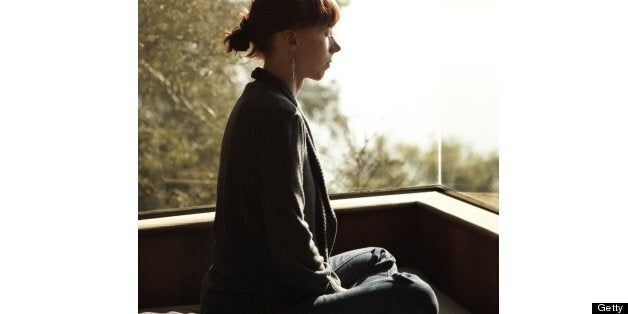 Woman relaxing in window seat looking out at clouds