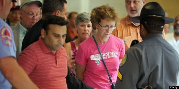 Janet Colm, CEO of Planned Parenthood of Central North Carolina, is arrested for an act of civil obedience at the North Carolina Legislative Building in downtown Raleigh, North Carolina, Monday, July 8, 2013. (Al Drago/Raleigh News & Observer/MCT via Getty Images)