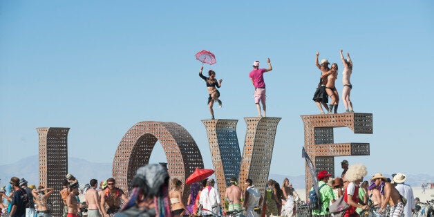 BLACK ROCK CITY, NV - SEPT 2: First-time Burner Sonja Lercer of Whistler, B.C., Canada, dances on the LOVE installation at last week's 25th annual Burning Man festival. (Photo by Keith Carlsen For the Washington Post)