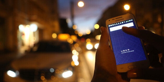 BERLIN, GERMANY - SEPTEMBER 02: In this photo illustration, a woman uses the Uber app on an Samsung smartphone on September 2, 2014 in Berlin, Germany. Uber, an app that allows passenger to buy rides from drivers who do not have taxi permits, has had its UberPop freelance driver service banned in Germany after a complaint by Taxi Deutschland, a trade association of taxi drivers in the country. The company, which operates in 42 countries over 200 cities worldwide, plans to both appeal the decision made by a court in Frankfurt as well as, at the risk of heavy fines, continue its services in Germany until a final decision has been made on the matter. (Photo by Adam Berry/Getty Images)