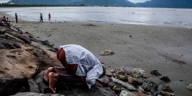 BANDA ACEH, INDONESIA - DECEMBER 26: Abdullah (58), a fisherman prays on the beach on December 26, 2014 in Banda Aceh, Indonesia. Aceh was the worst hit location, being the closest major city to the epicentre of the 9.1 magnitude quake, suffering a huge hit from the following tsunami and resulting in around 130,000 deaths. Throughout the affected region of eleven countries, nearly 230,000 people were killed, making it one of the deadliest natural disasters in recorded history. (Photo by Ulet Ifansasti/Getty Images)